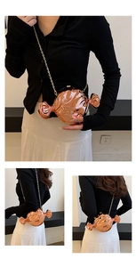 Close-up of rose gold candy-shaped crossbody bag with metallic finish and gold chain