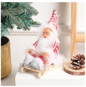 Detailed close-up of knitted Santa Claus figurine on a wooden sled with rustic textures
