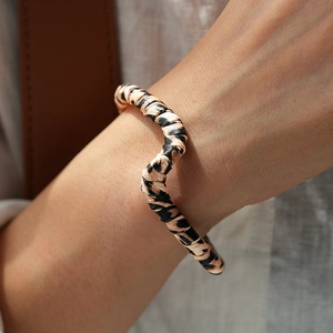 Close-up of vintage leopard print leather open cuff bracelet on female model wrist