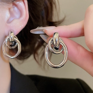 Macro detail of silver interlocking double hoop earrings with a polished metallic finish