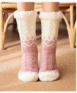 Close-up of pink and white cable-knit socks with plush lining and heart patterns