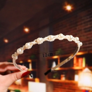 Detail shot of a 12cm beaded headband with white imitation pearls and a slim metal frame