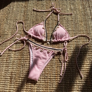 Detail of pink seersucker bikini with shell charms and sea star decorations