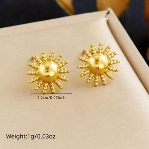 Macro shot of 1.2cm gold sun stud earrings with weight and size info on beige tray