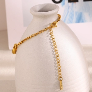 Detail der 18K vergoldeten Edelstahlkette mit Karabinerverschluss und Logoanhänger