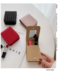 Close-up of wavy leather lipstick pouch with mirror and button closure in four colors