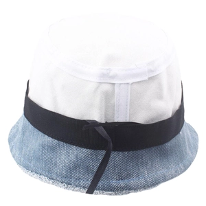 Detail of two-tone bucket hat with white canvas crown, blue denim brim, and black ribbon band