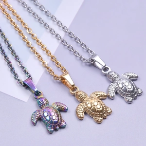 Detailed shot of turtle pendants in silver, gold, and rainbow stainless steel finishes