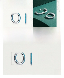 Detail of 925 sterling silver hoop earrings with turquoise inlays and heart cutouts