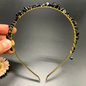 Detail view of handcrafted gold crown headband with black natural crystal stones