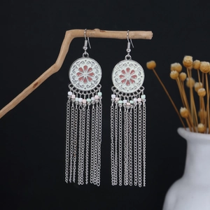 Detailed shot of silver tassel earrings with pink enamel flower and color beads
