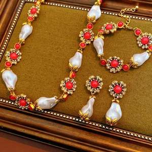 Luxurious vintage jewelry set with pearls and red gems displayed in a golden frame