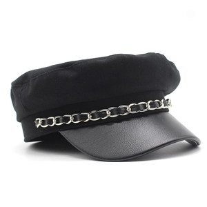 Detail of black wool newsboy hat with textured faux leather brim and silver chain trim