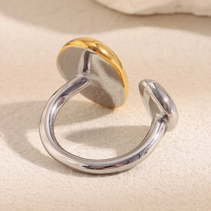 Macro shot of two-tone gold and silver irregular open ring on beige felt