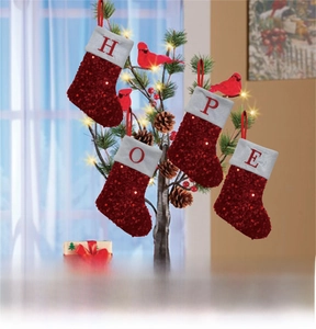 Detail of four red sequined Christmas stockings with HOPE embroidered letters on a tree