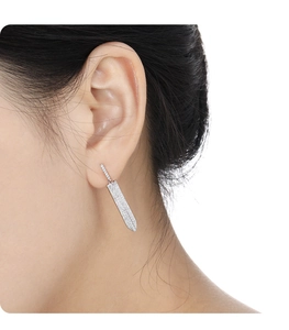 Close-up of model wearing silver sword-shaped stud earrings with pavé-set zircons