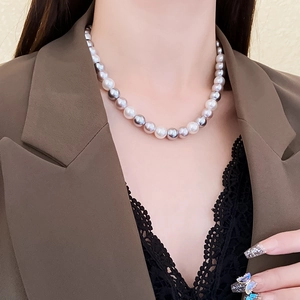 Close-up of elegant gradient grey and white pearl necklace worn with a blazer