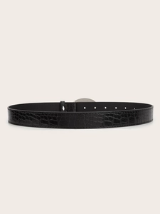 Close-up of black crocodile embossed leather belt with silver buckle on beige backdrop