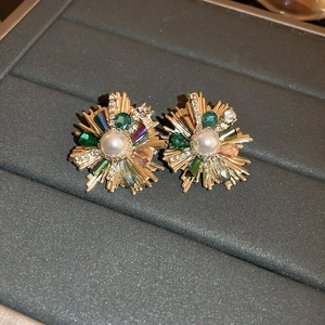 Macro shot of vintage floral earrings with pearls and colorful crystals on a velvet tray