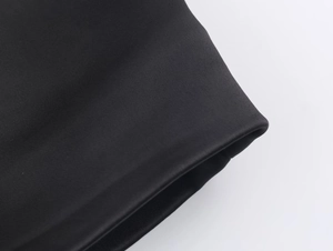 Dettaglio della texture in raso nero di qualità e cuciture rifinite per tailleur donna