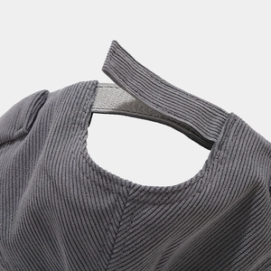 Gros plan d'un bonnet en velours côtelé gris avec fermeture velcro réglable.