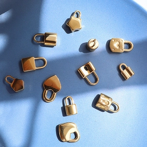 18K gold plated heart and square padlock pendants on a textured blue background