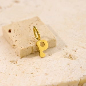 Macro detail of polished gold-plated letter P pendant on a natural stone background