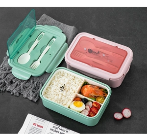 Detail view of pink and green divided lunch boxes with built-in cutlery and meal prep