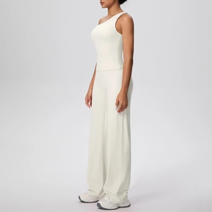 Détail d'un ensemble de yoga blanc cassé à une épaule et pantalon large côtelé