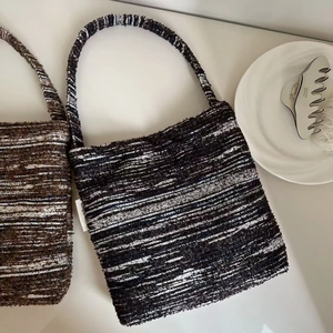 Detailed close-up of retro knitted tote bags with textured patterns and simple brand label