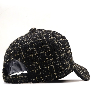 Détail de la casquette en tweed noir et doré avec texture tissée et ouverture arrière
