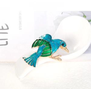 Macro detail of kingfisher brooch with blue and green enamel and gold plated finish