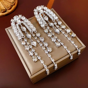 Macro shot of silver teardrop crystal earrings with elegant long fringe tassel details
