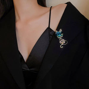Elegant cat brooch with deep blue gemstone and colorful crystals on a black suit blazer