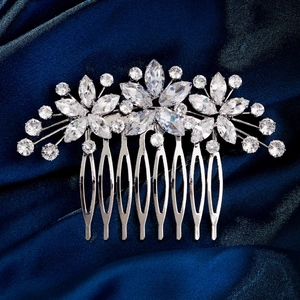 Gros plan d'un peigne à cheveux de mariée argenté avec zircons sur soie bleue