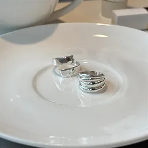 Detail of 925 sterling silver spiral and multi-layer rings on white ceramic plate