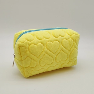 Detailed view of yellow plush pencil case featuring 3D heart quilted texture and blue zipper