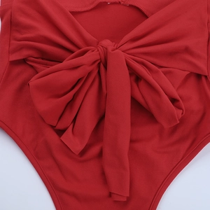 Close-up of red halter backless bodysuit with detailed bow tie texture and fabric detail