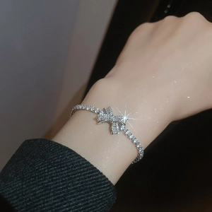 Macro shot of sparkling zircon bow bracelet showing exquisite craftsmanship and silver chain