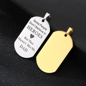 Detailed macro view of engraved silver and polished gold stainless steel dog tags for dads