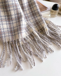 Close-up of soft plaid cashmere scarf with long fringe and detailed knit texture