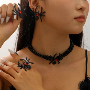 Detailed shot of Gothic black spider necklace and earrings with red crystals
