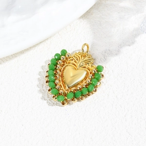 Detailed macro view of heart pendant with gold center and green faceted beads