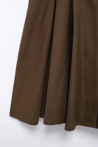 Close-up of brown houndstooth fabric texture on vintage-style bow mini dress