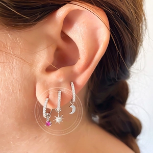 Macro view of flower diamond ear set featuring pink gem, star, and moon charms