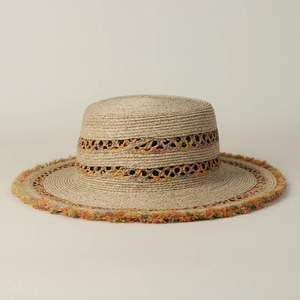 Dettaglio cappello di paglia boho con bordi sfrangiati colorati e fascia intrecciata cava