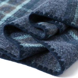 Close-up detail of soft blue plaid cashmere scarf with thick wool texture and stitching