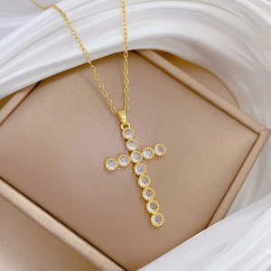 Elegant gold titanium steel cross necklace with brilliant zircons on champagne jewelry box