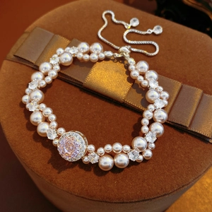 Dettaglio del bracciale di perle a due file con gemma rosa su astuccio velluto