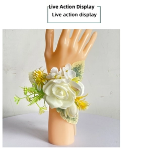 Detail of white rose wrist corsage with yellow daisy and green leaves on ribbon